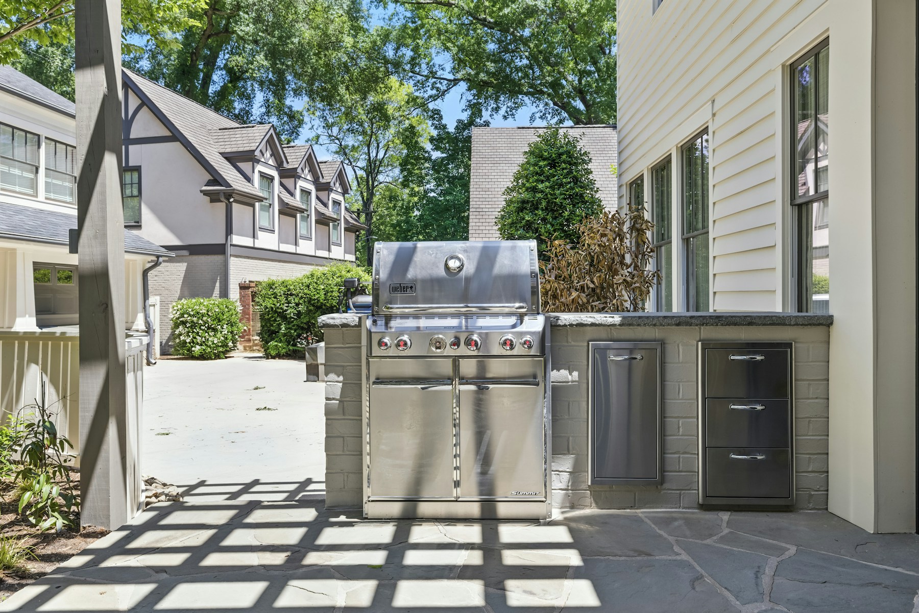 Stainless steel grill beside built-in cabinets on a covered outdoor deck